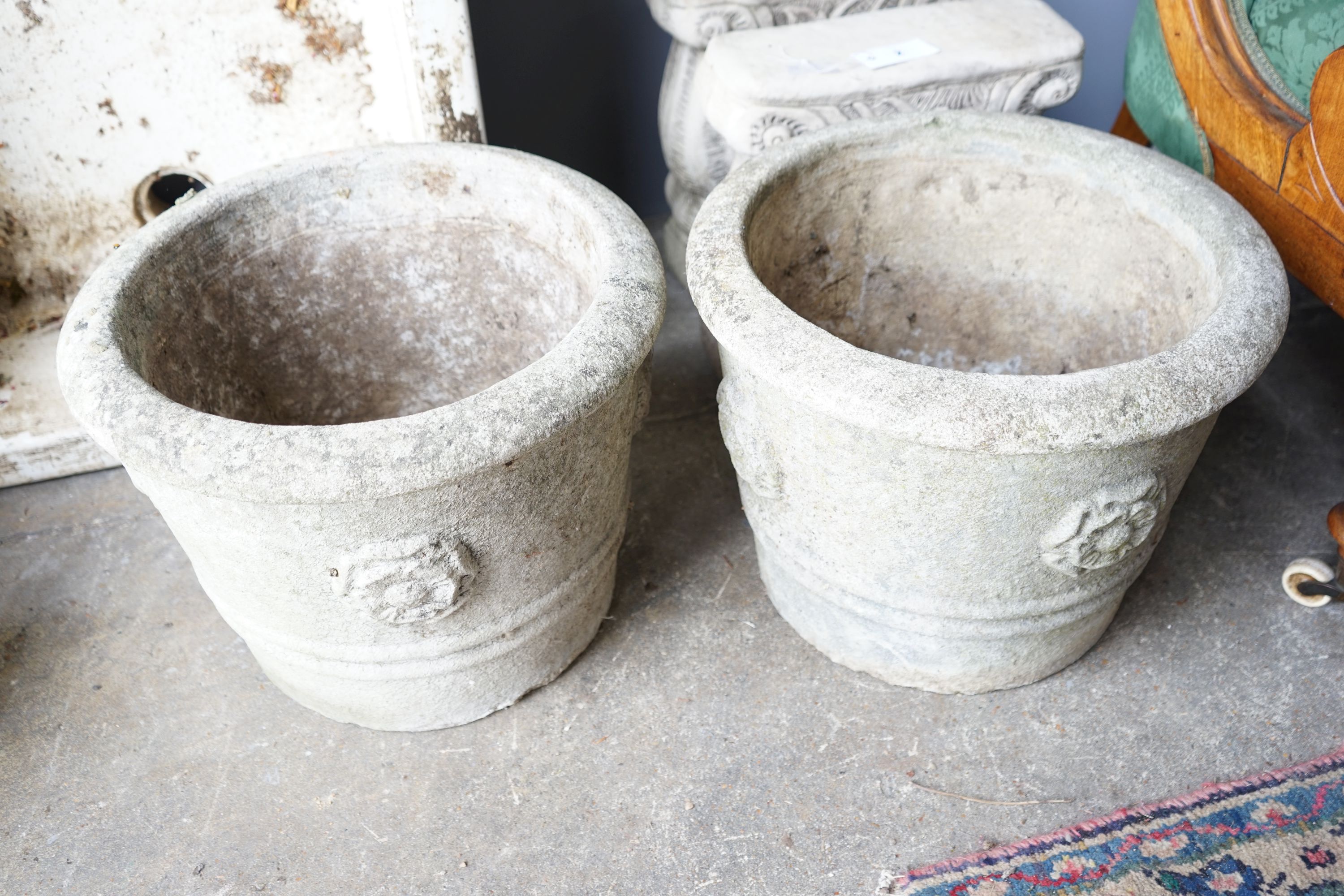 A pair of circular reconstituted stone garden planters, diameter 42cm together with a pair of stone bench supports